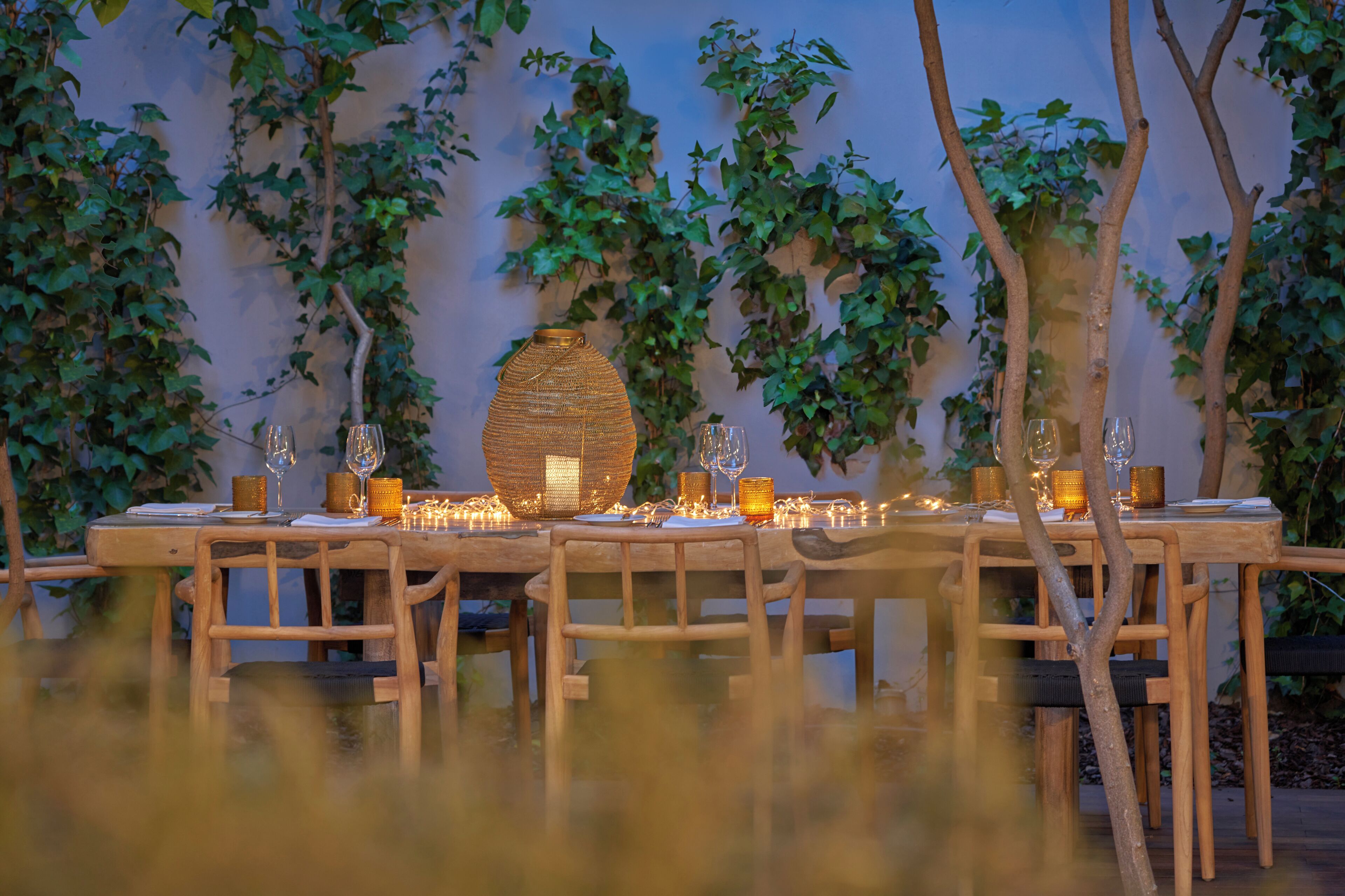 A table set for a meal with candles and a decorative centerpiece.