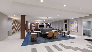 Eine moderne Hotelhalle mit Sitzgelegenheit, einem Fernseher und einer Treppe.