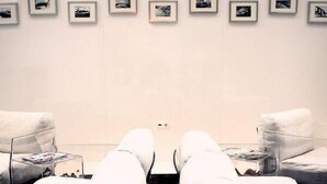 A room with two reclining chairs, a wall with framed pictures, and a door. - Costa Verde (Povoa De Varzim)