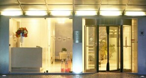 A hotel entrance with a reception desk, a glass door entrance, and a sign indicating the hotel name. - Costa Verde (Povoa De Varzim)