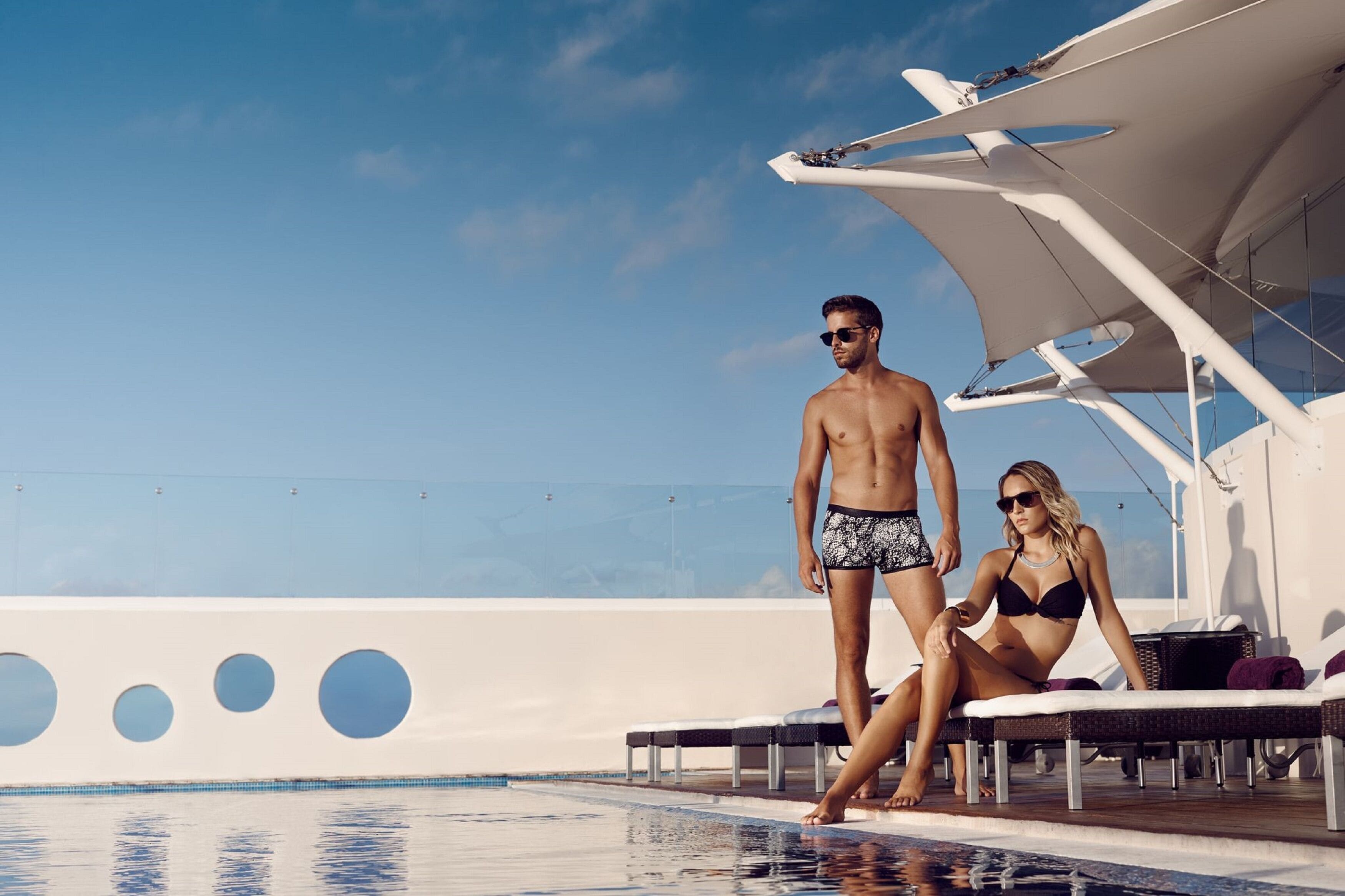 A yacht with a swimming pool, lounge chairs, and a clear sky.