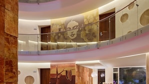 A multi-level interior with a modern design, featuring a central staircase, glass railings, and a seating area with a view of the lower level. - Senses Quinta Avenida By Artisan Adults Only (Playa del Carmen)