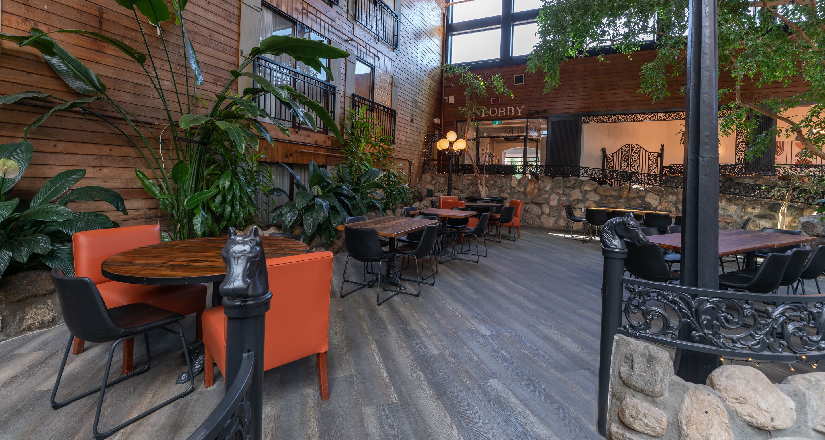 An indoor dining area with wooden walls, stone accents, and multiple tables and chairs.
