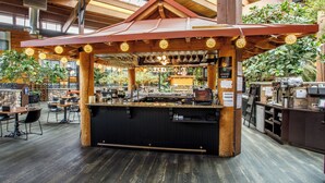 A restaurant with a bar area, wooden ceiling, and indoor plants. - Prestige Vernon Lodge and Conference Centre (Vernon)