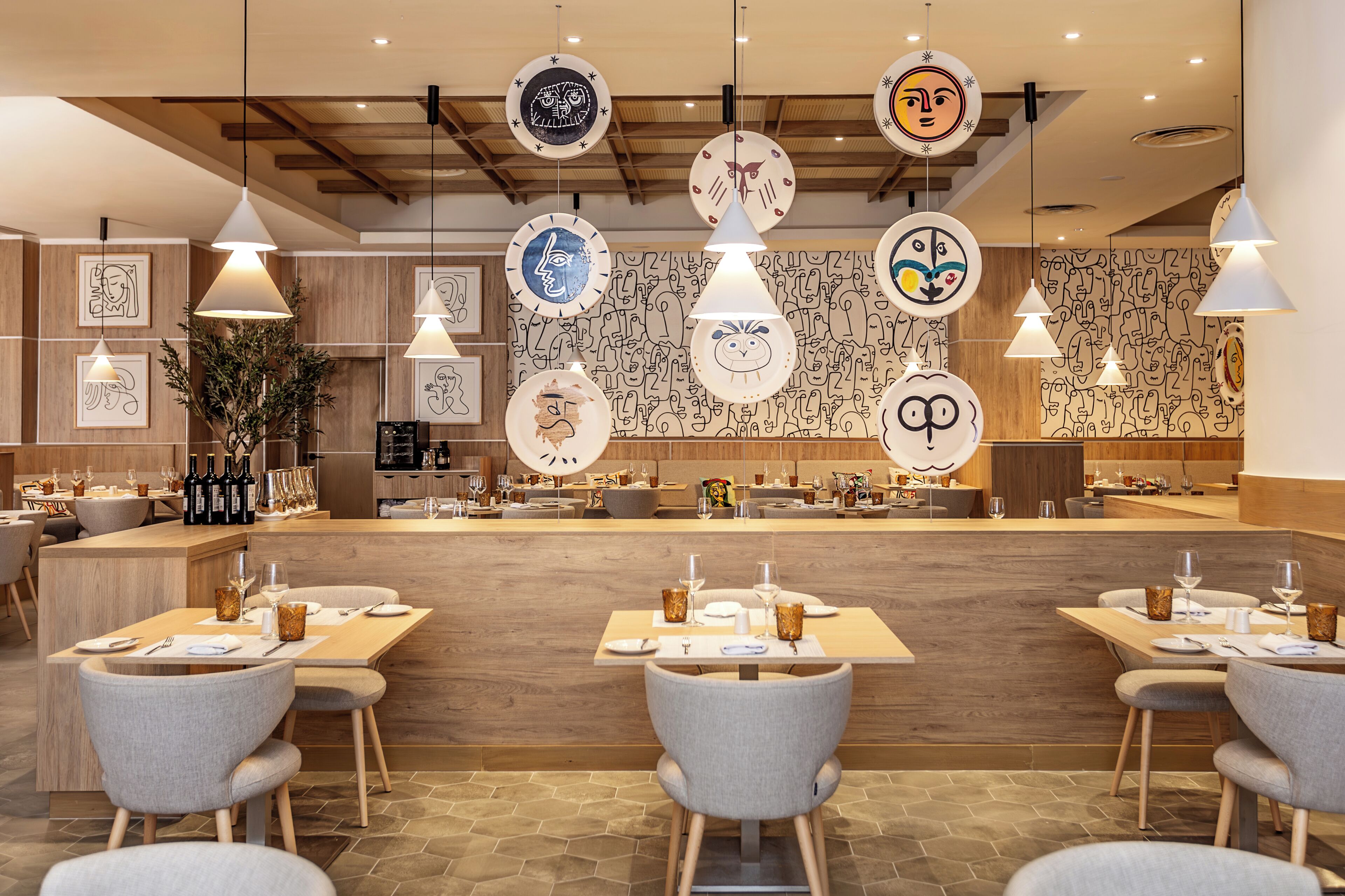 Interior de restaurante con paredes de madera, iluminación colgante y una barra con diversos platos.