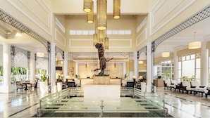 A spacious lobby with a central reception desk, multiple seating areas, and a glass barrier. - Bahia Principe Escape Runaway Bay - Hyatt Inclusive Collection - Adults Only - All Inclusive (Runaway Bay)