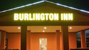 The exterior of Burlington Inn with a neon sign, a covered entrance, and a visible door. - Burlington Inn (Burlington)