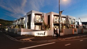 A modern building with a sign reading "The Sails." It features a prominent staircase and large windows.