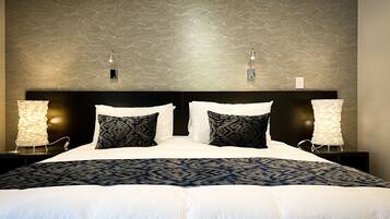 A neatly made bed with a patterned bedspread, two bedside lamps, and a textured wall behind.