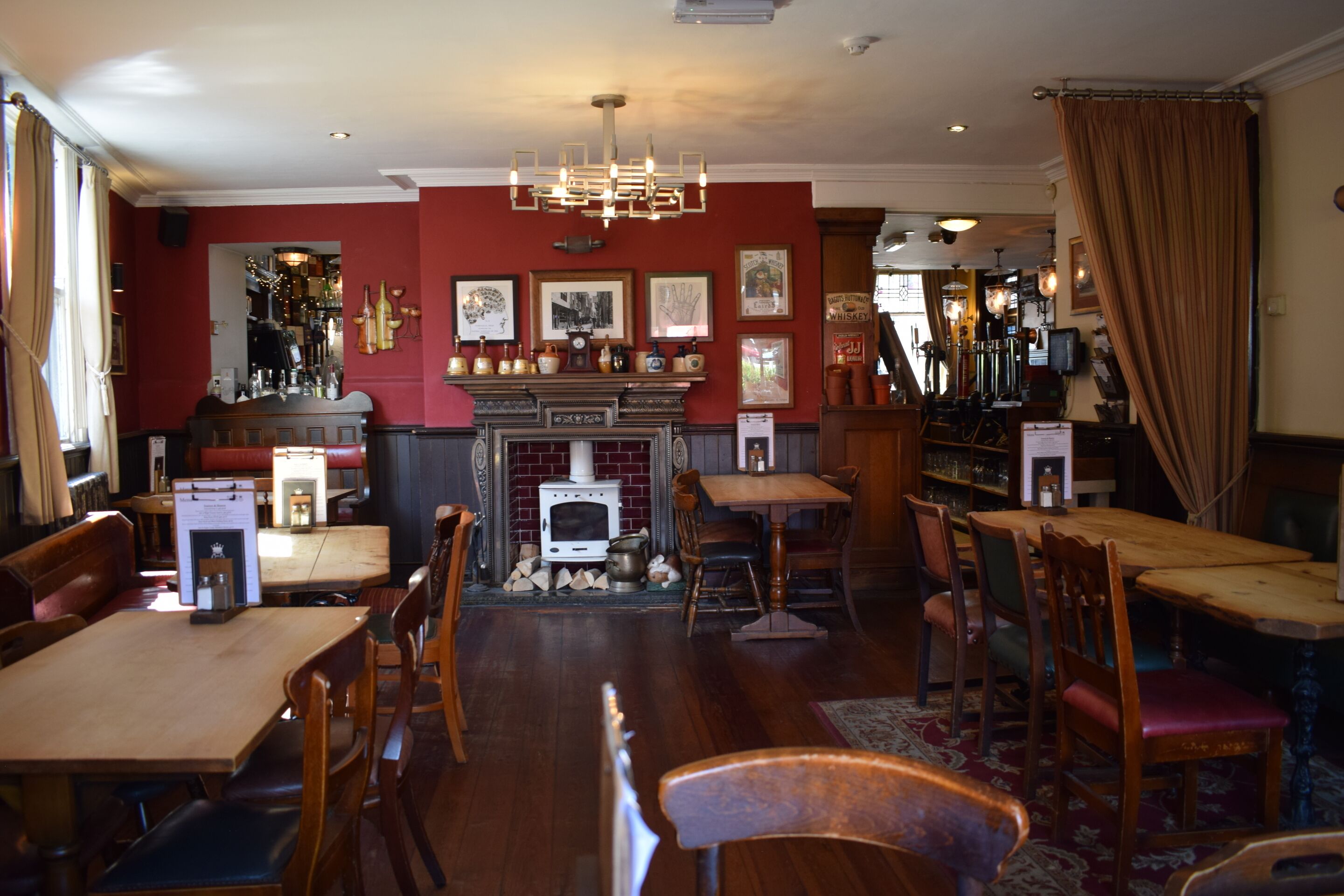 Un pub acogedor con muebles de madera, una chimenea y diversas fotos enmarcadas en las paredes.