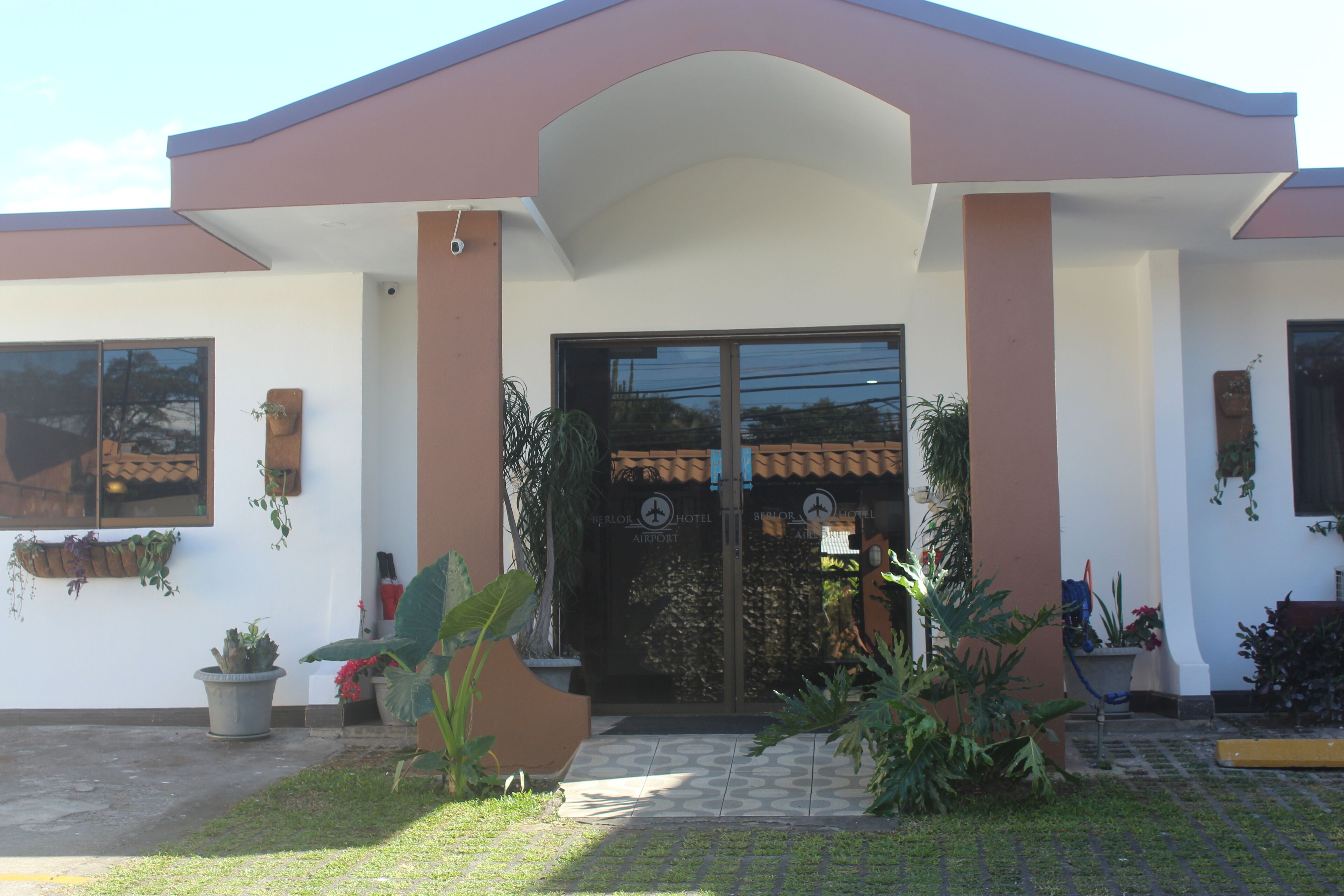 A hotel entrance with a modern design, featuring a large glass door and a welcoming archway.