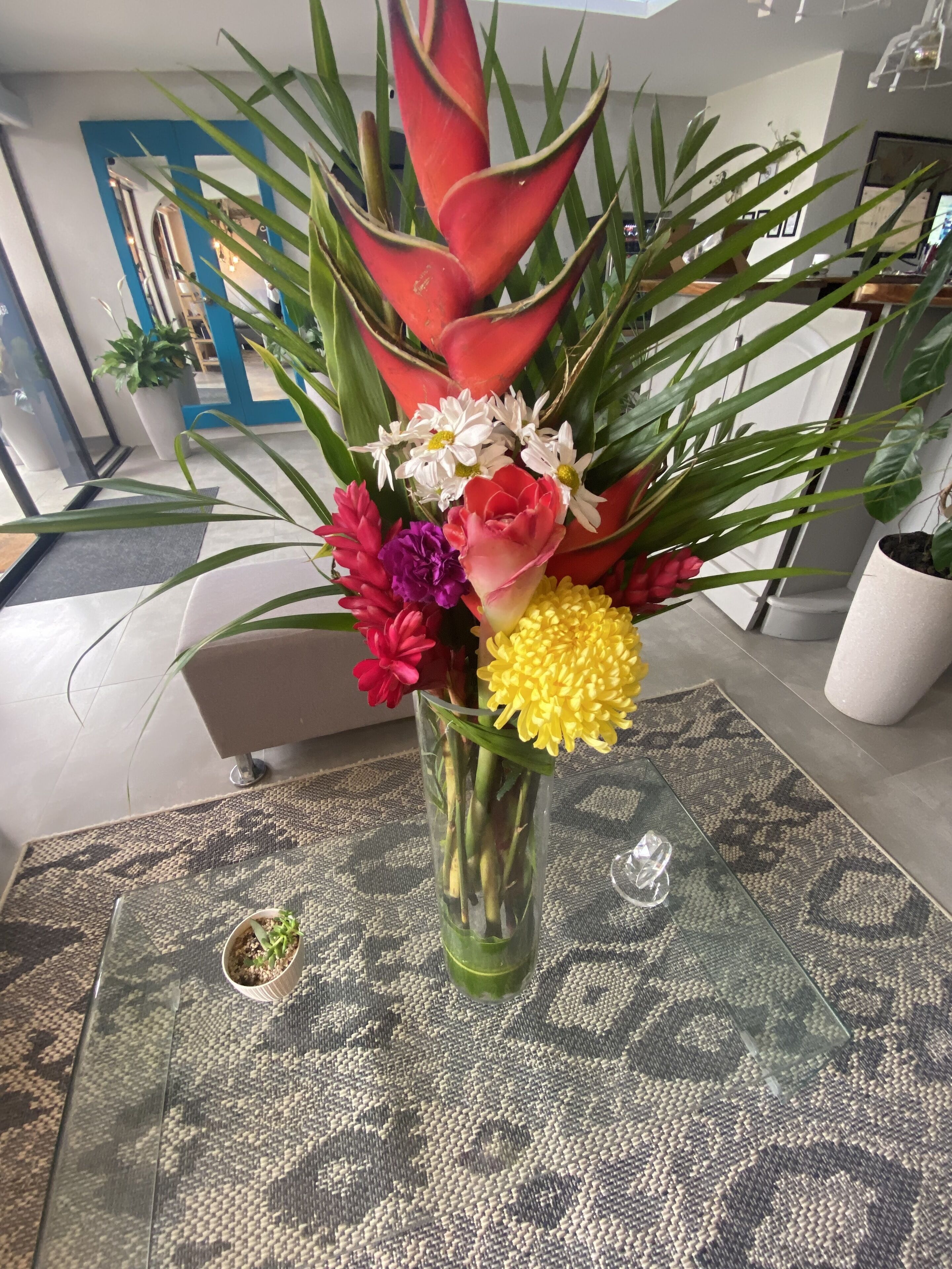 A vase with a floral arrangement on a patterned tablecloth.