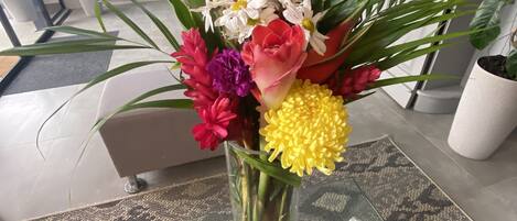 A vase with a floral arrangement on a patterned tablecloth.