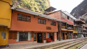 A train station with a building labeled "La Payacha" and a "Full House" store. - Hostal La Payacha (Machu Picchu)