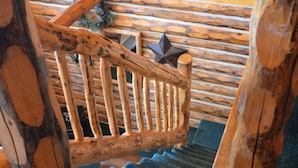 A wooden staircase with a rustic design, featuring a handrail and a star-shaped decoration at the top.