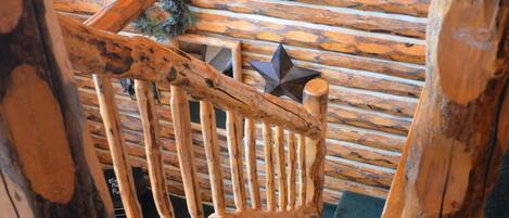 Una escalera de madera de diseño rústico, con barandilla y una decoración en forma de estrella en la parte superior.