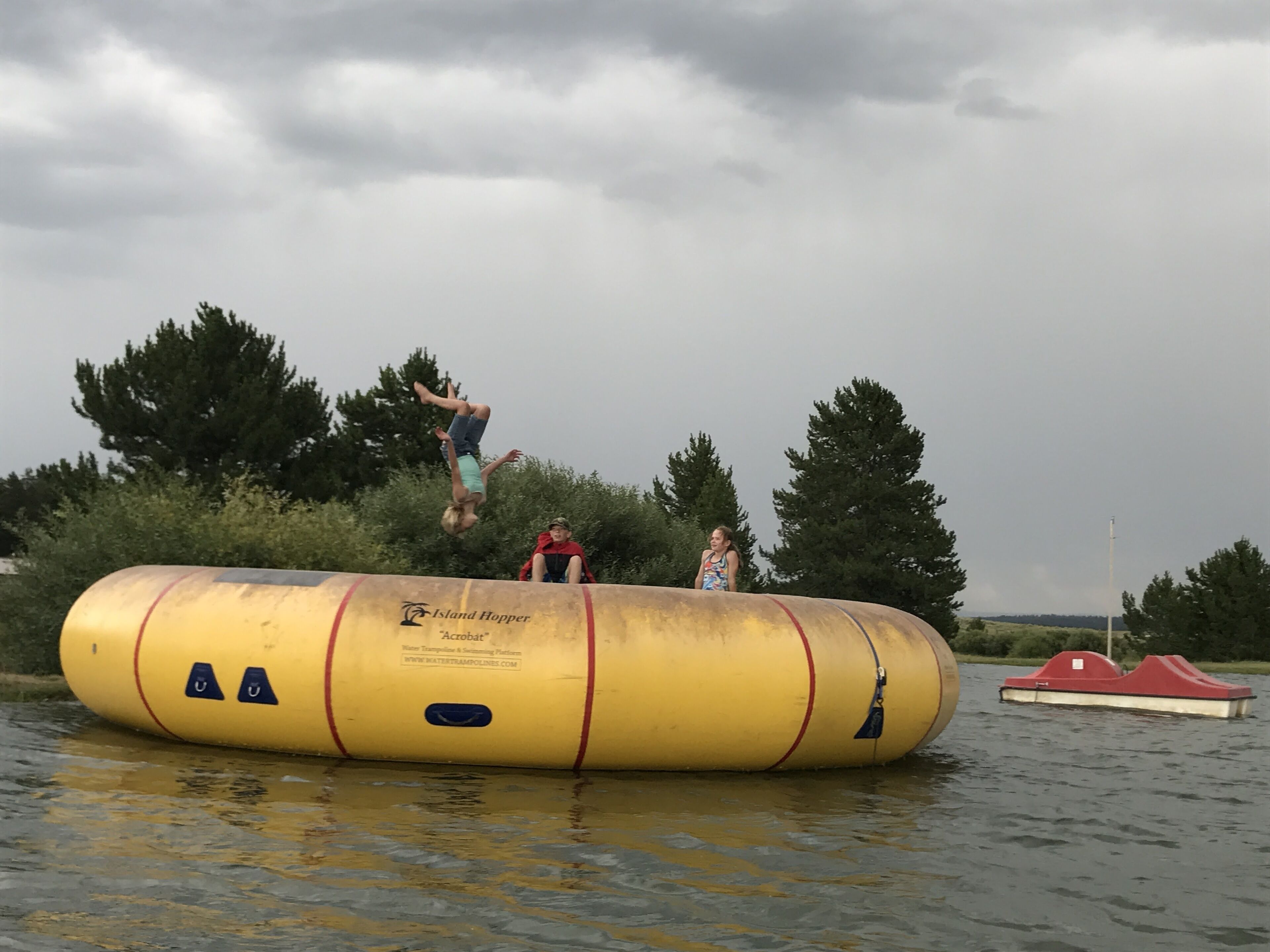 A water trampoline with a person performing a flip.