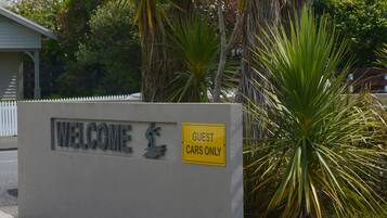 A welcome sign with a guest car only sign.