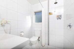 A bathroom with a bathtub, toilet, and shower.