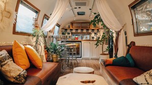 A cozy interior with a sofa, ottoman, and dining area. - 8Hotel (Fujisawa)