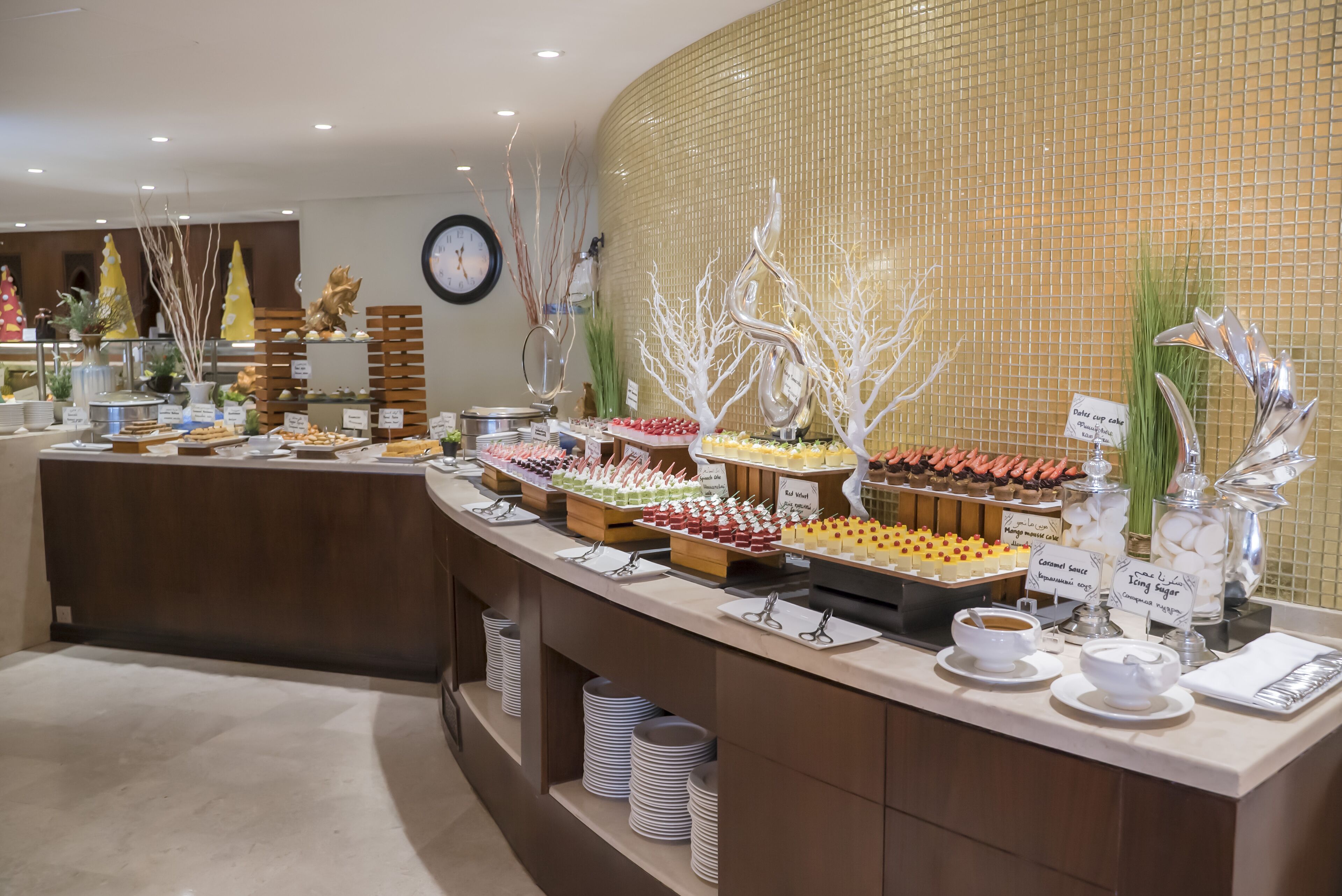 A buffet with various food items and drink stations, including a sign for 'Caramel Sauce'.