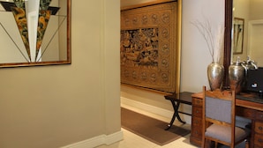 A room with a large ornate tapestry, a desk with a computer, and a chair. - Long Street Boutique Hotel (Cape Town)