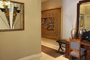 Una habitación con un tapiz grande y ornamentado, un escritorio con una computadora y una silla.