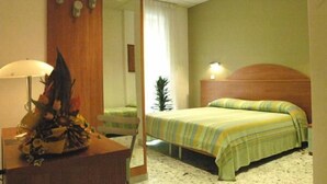 A hotel room with a bed, a nightstand, a mirror, and a lamp. - B&B Vittoria (Maiori)