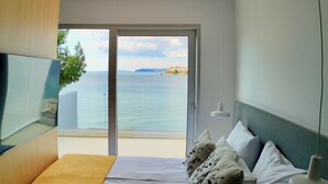 A bedroom with a bed, pillows, and a view of the sea. - Hotel Split (Podstrana)