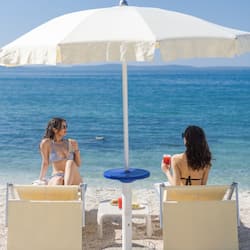En la playa, arena blanca, sillas reclinables de playa, toallas de playa