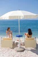 On the beach, white sand, sun loungers, beach towels