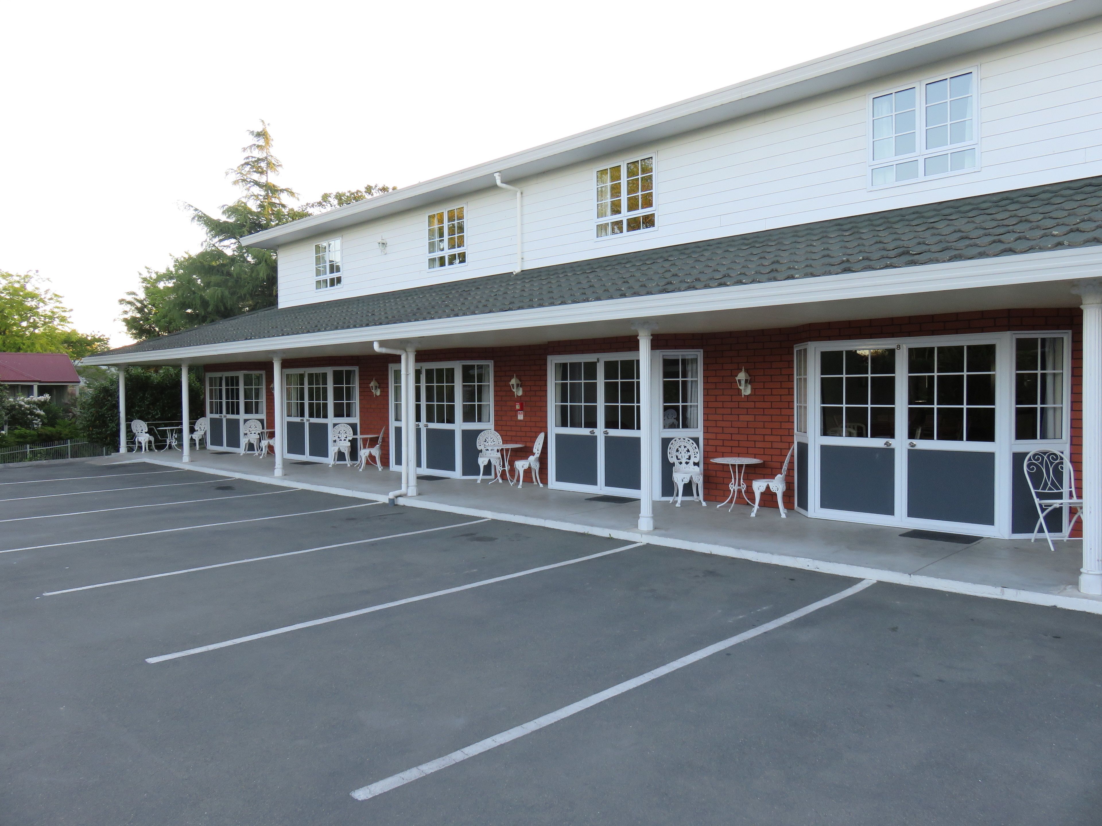 A building with a covered patio area, multiple windows, and outdoor seating.