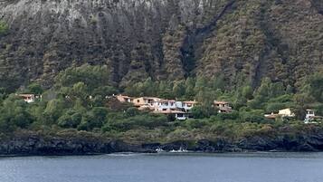 Una propiedad costera con varias construcciones ubicadas entre abundante vegetación en una ladera.