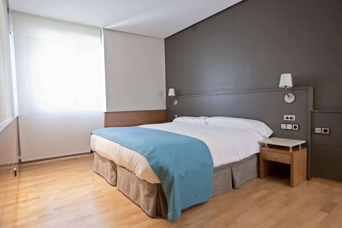A modern bedroom with a bed, bedside table, and a nightstand.