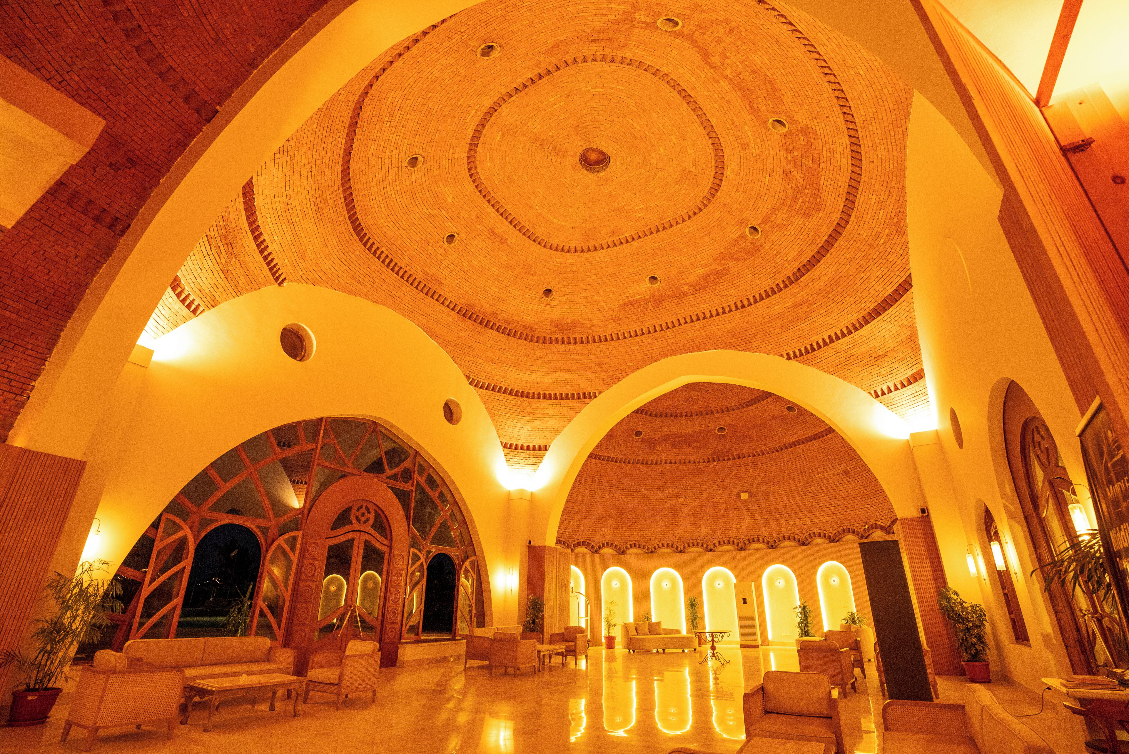 Um hall amplo com teto alto e circular, e várias abóbadas.