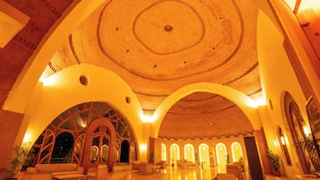 Um hall amplo com teto alto e circular, e várias abóbadas.