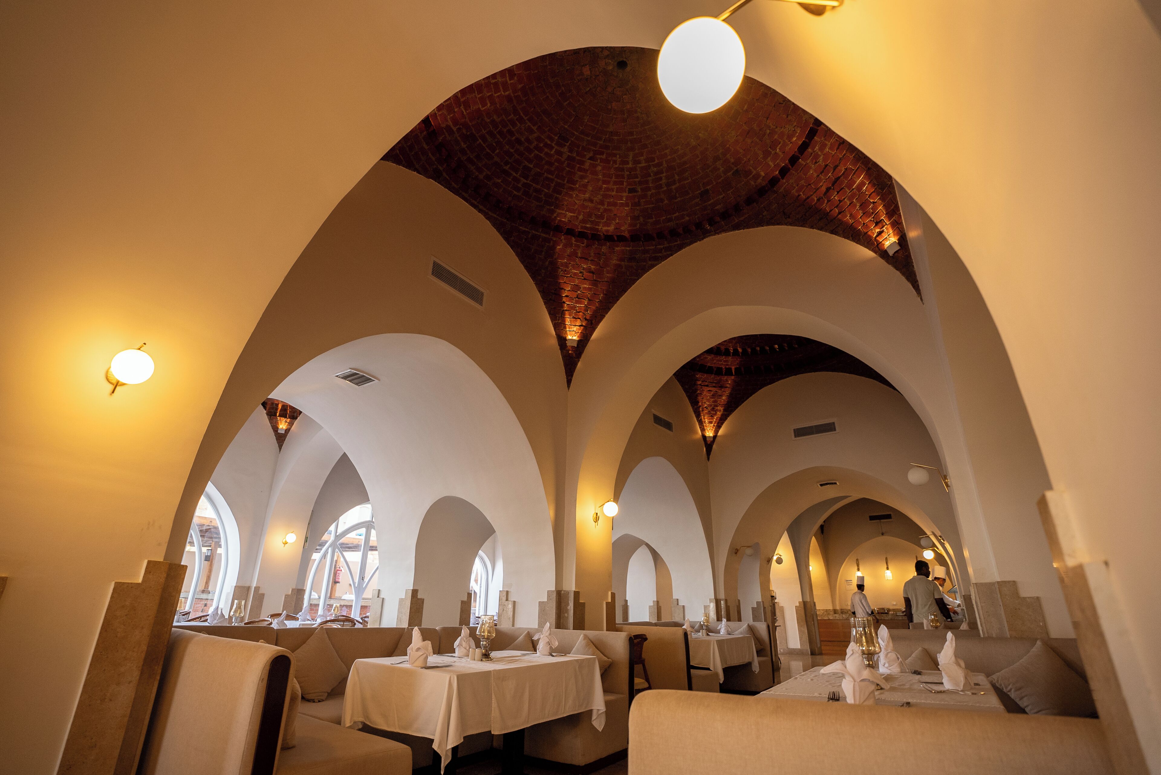 Un restaurante con techos abovedados y mesas dispuestas para comer.