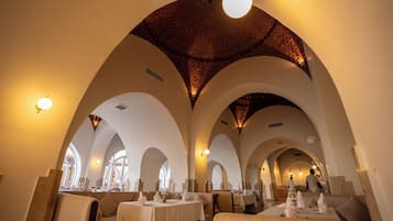 Un restaurante con techos abovedados y mesas dispuestas para comer.