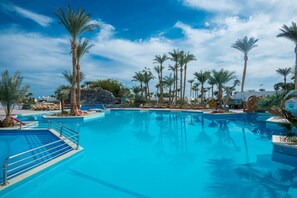 A large outdoor swimming pool surrounded by palm trees and lounge chairs. - Shams Safaga Resort - All inclusive (Safaga)