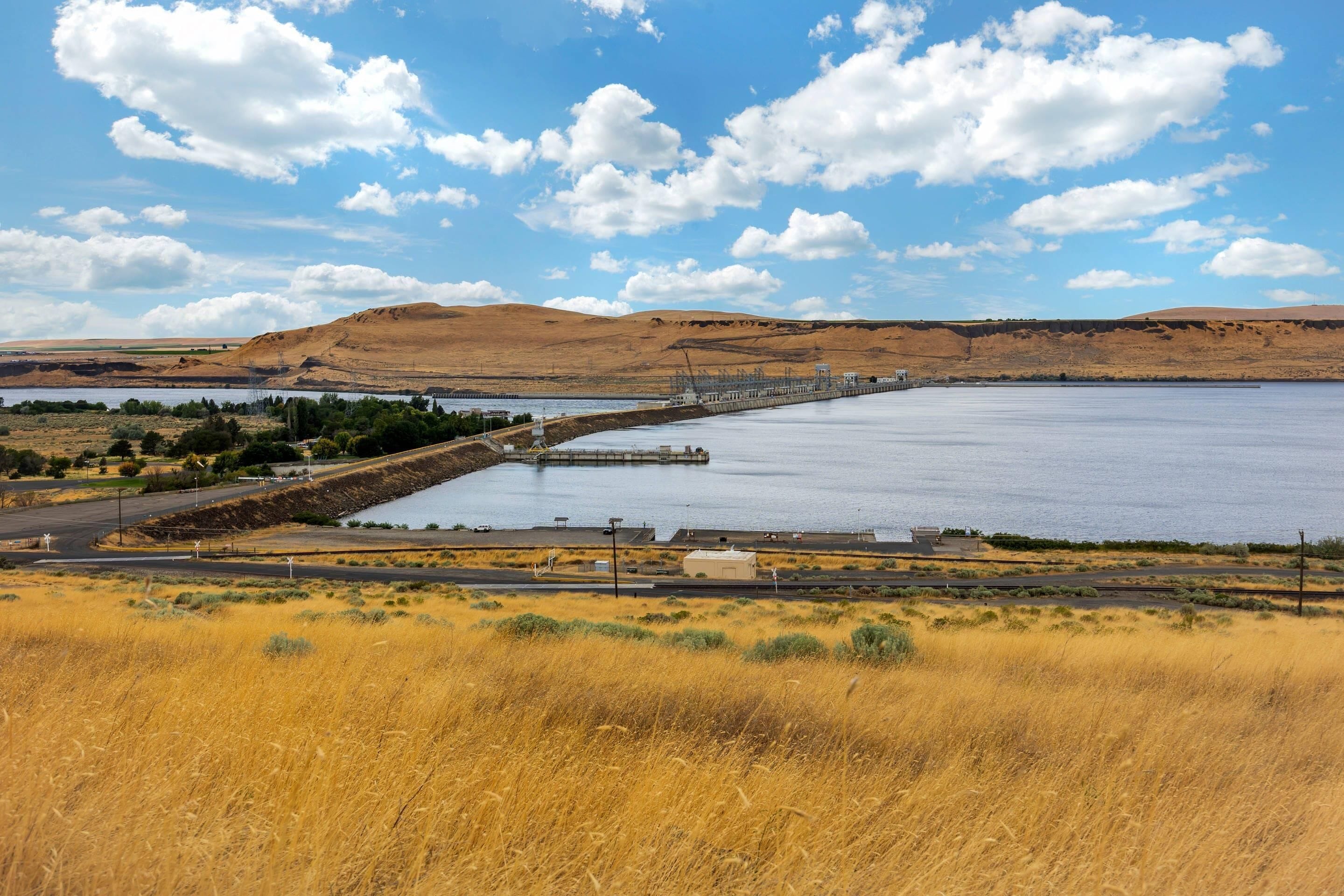 A large body of water with a bridge and industrial structures in the background.