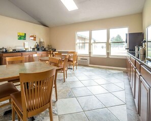A spacious kitchen with a dining area, large windows, and a view of the outdoors.