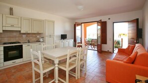 A compact living space with a kitchen, dining area, and a sofa. - Borgo Etrusco S.p.A. (Scarlino)