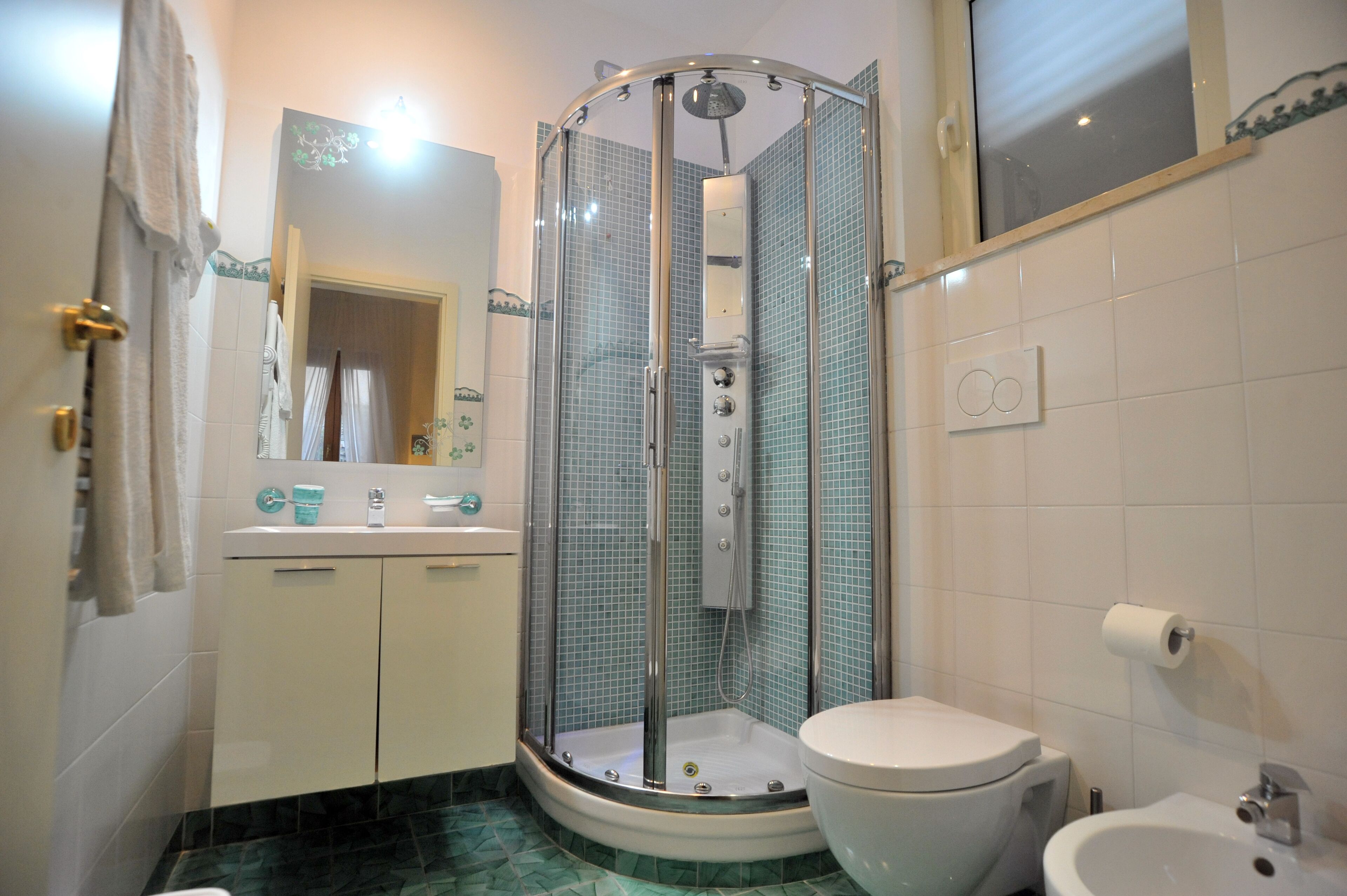 Une salle de bain comprenant une douche à parois de verre, des toilettes, un bidet et un lavabo.