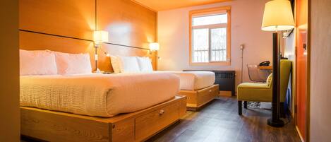 A modern hotel room with a large bed, bedside tables, a desk, and a chair.