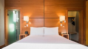 A large bed with a white bedspread, two bedside lamps, and a wooden headboard. - The Adventure Hotel (Nelson)