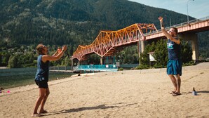 A beach with a metal bridge in the background. - The Adventure Hotel (Nelson)