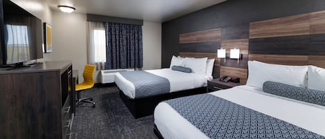 Een hotelkamer met twee bedden, een bureau, een televisie en een stoel.