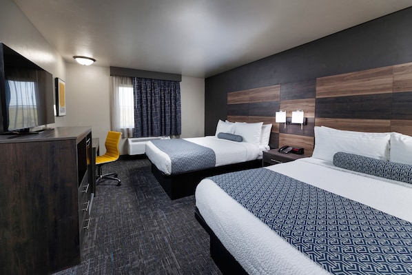 A hotel room with two beds, a desk, a TV, and a chair. - Hotel J Green Bay (Green Bay)