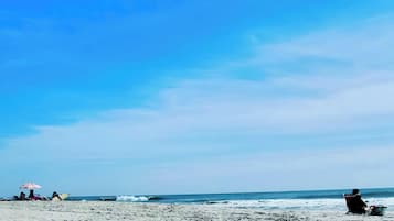 Una playa cerca, sombrillas, toallas de playa