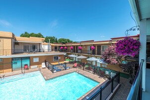 Una piscina al aire libre de temporada, sombrillas